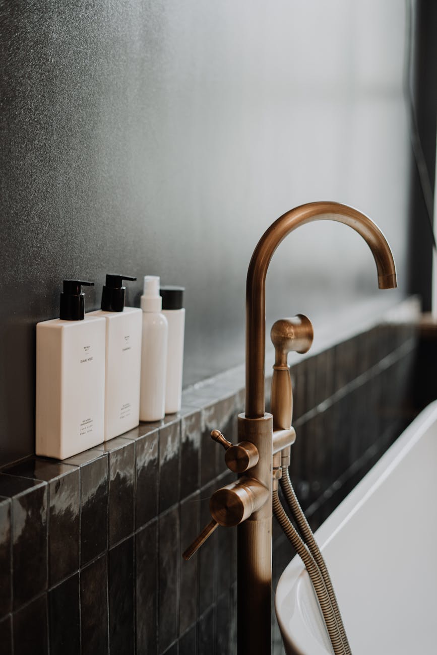 brass faucet with white ceramic bathtub